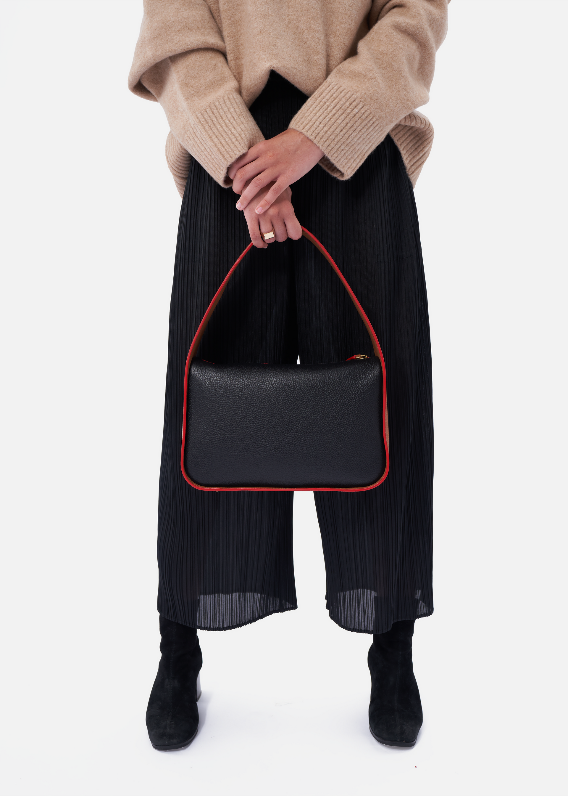 Grete pebble leather shoulder bag in black / caramel with red edge